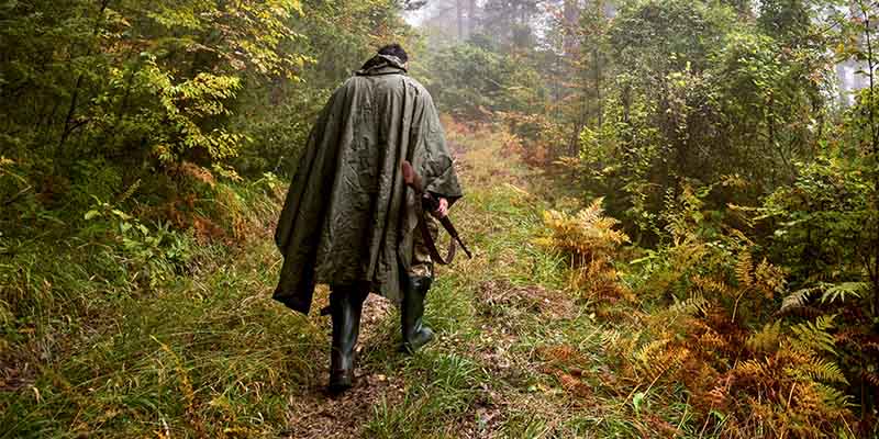 Nässeschutz Ein Mann im Wald bei Nässe